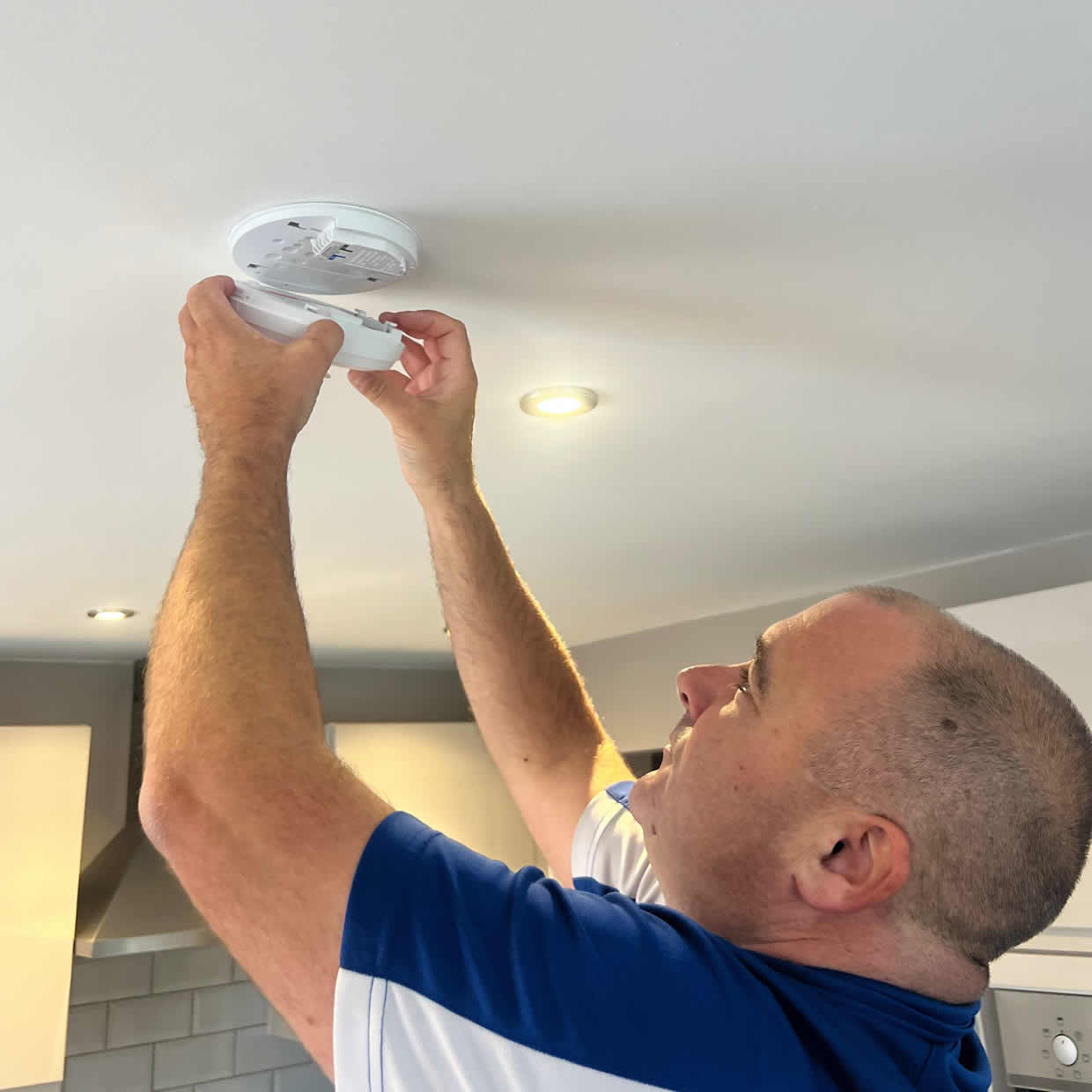 Smoke alarm installer fitting an alarm in a Hinckley property